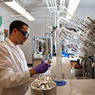 A researcher in a lab reviewing his findings