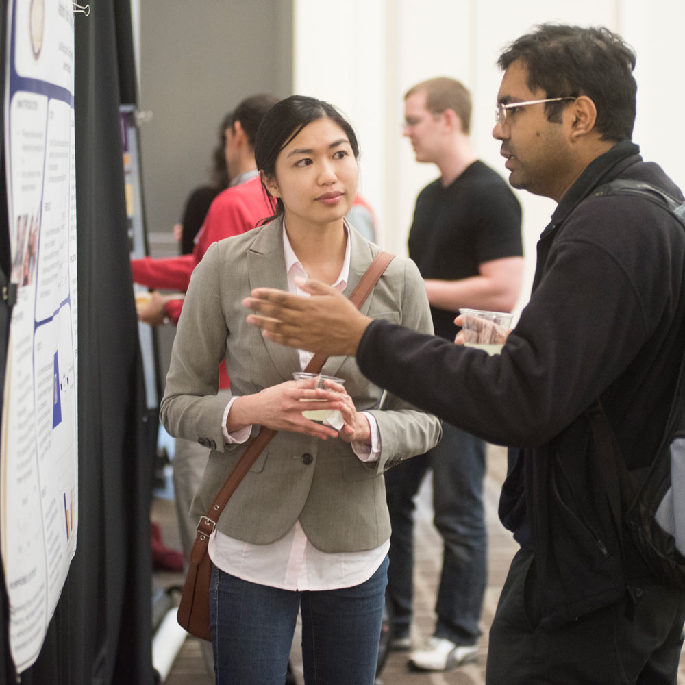 "Two Students discuss a business plan at an event"