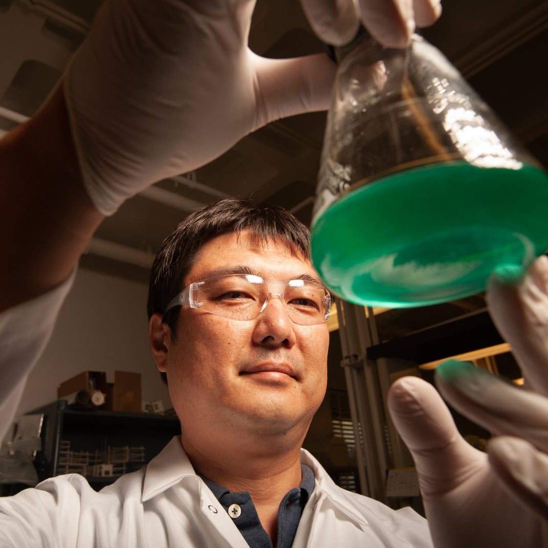 "Researcher posing with beaker"