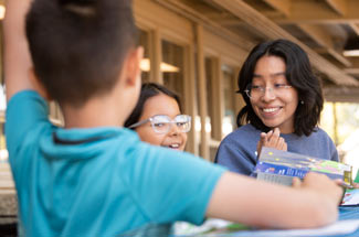 Student talks with young children