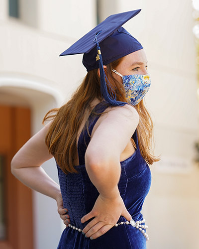 Student wears grad cap and face covering.