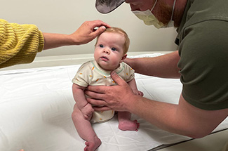 Boy sits on doctor's examination table