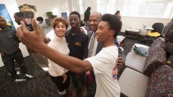 Yusuph Lawal, biological sciences major, Camille Chargois, communications major, and Nate Walker, biological science major, get a selfie with UC Davis Chancellor Gary May at the Center of African Diaspora Student Success on December 1, 2017.