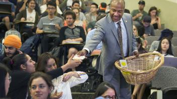 Chancellor May hands out cookies to the students in BIS 103 part of a surprise visit to award Professor Judy Callis the UC Davis Prize for Undergraduate Teaching and Scholarly Achievement.