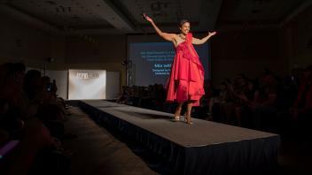 LeShelle May, wife of Chancellor May, models a student-designed dress for the Picnic Day Fashion Show. The Red Dress collection is part of a national symbol encouraging women to reduce their risks of heart disease.