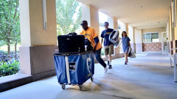 UC Davis Chancellor, Gary May helps a family of a new student move-in to the Tercero Residence halls.