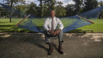 UC Davis Chancellor Gary May sits in a hammock in the quad