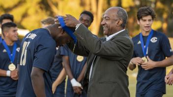 Chancellor May places a medal around the neck of a soccer player at UC Davis.