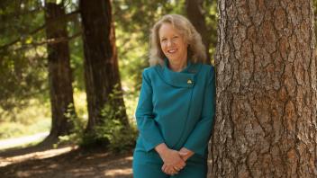 provost mary croughan poses at a tree