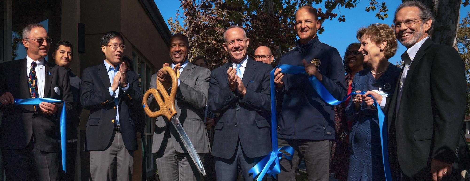 Chancellor Gary May and a team of people cut a ribbon at UC Davis Aggie Square