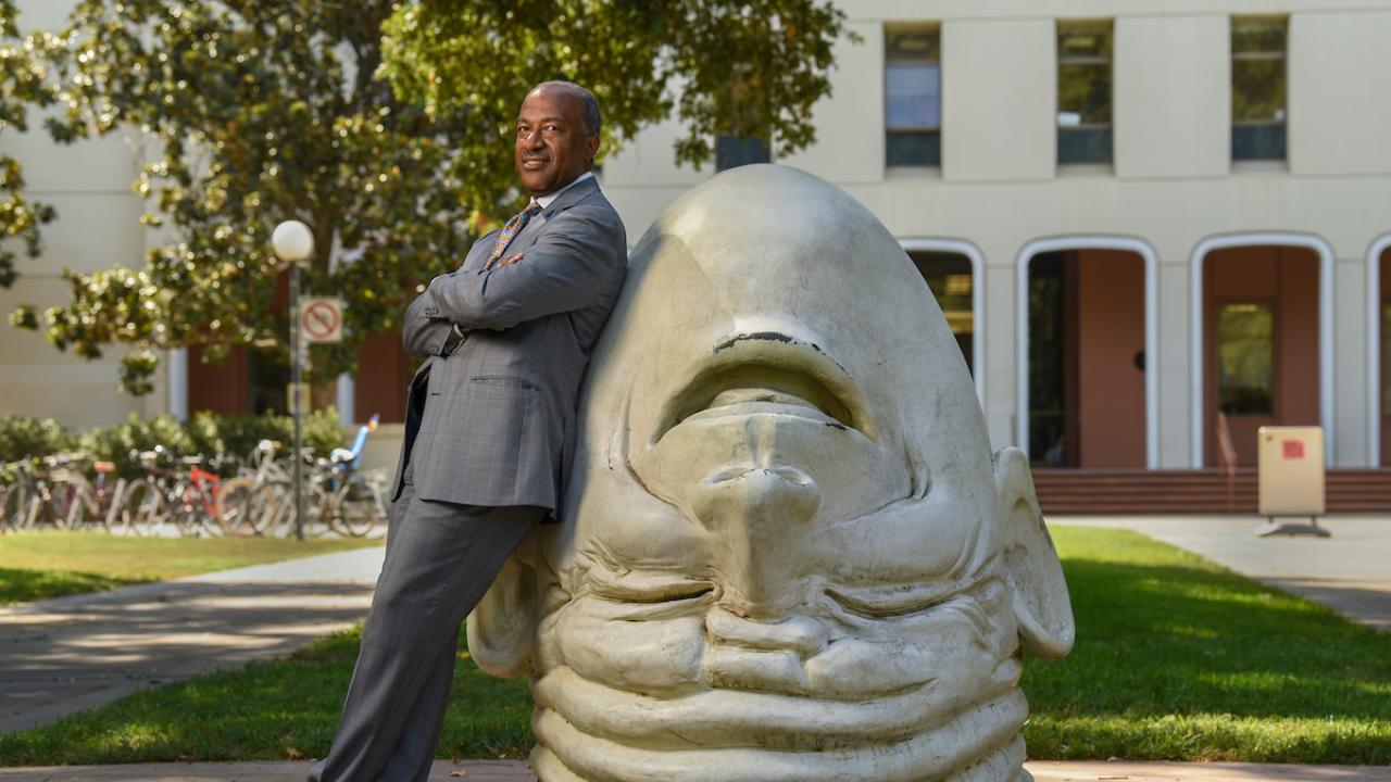 Chancellor May leaning on an Egghead in front of Mrak Hall. 