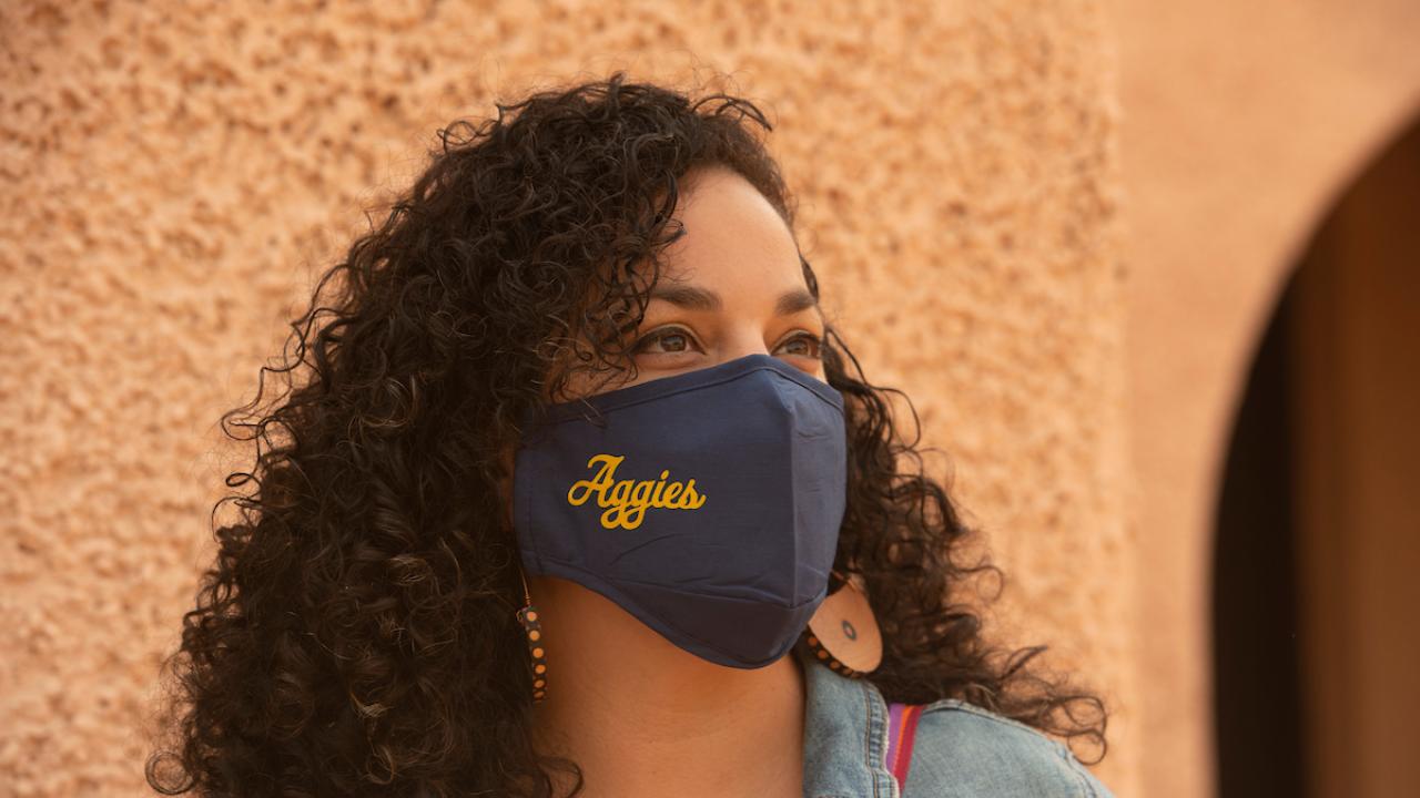 Sequoia Erasmus, a graduate student studying transportation technology and policy and landscape design, models a branded face covering at the Davis Amtrak station. (Gregory Urquiaga/UC Davis)