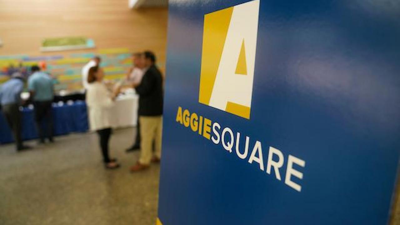 Blue and yellow sign with the Aggie Square logo.