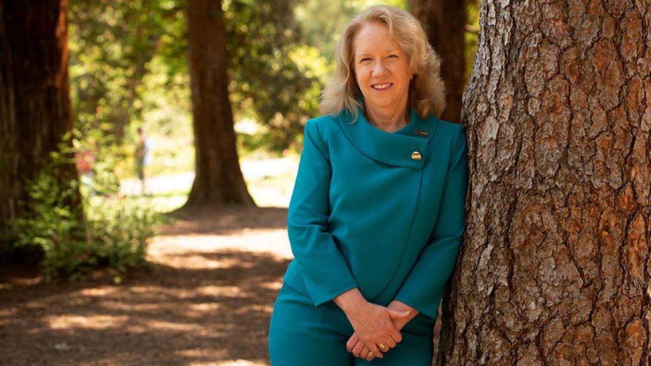 Provost Croughan leaning on a tree looking at camera.