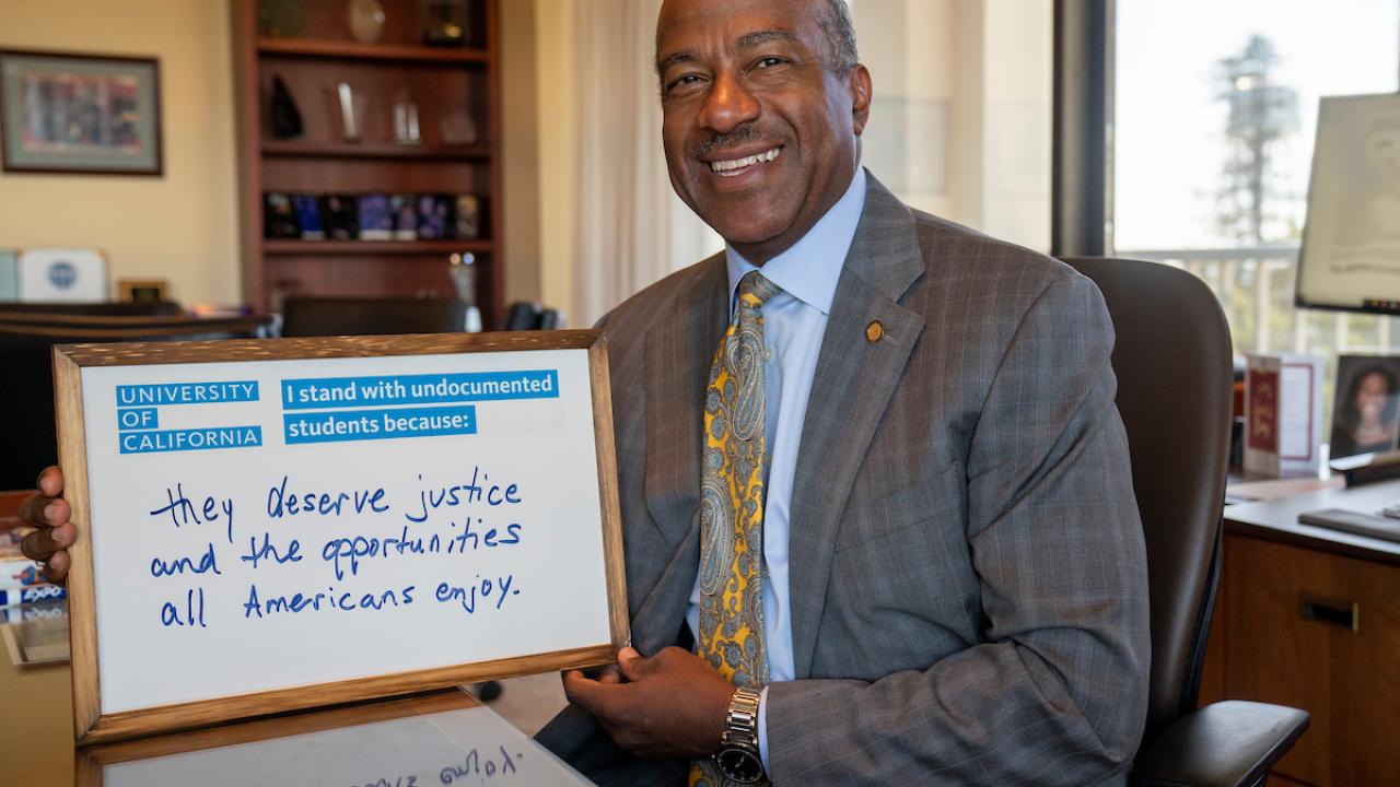 Chancellor May holds up sign that states: I stand with undocumented students because they deserve the justice and opportunities all Americans enjoy.