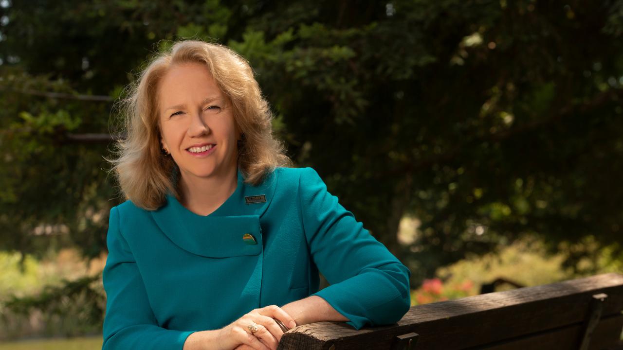 Provost Mary Croughan sitting outside wearing teal suit