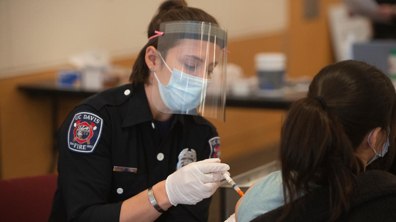 UC Davis Firefighter administering vaccine to patient