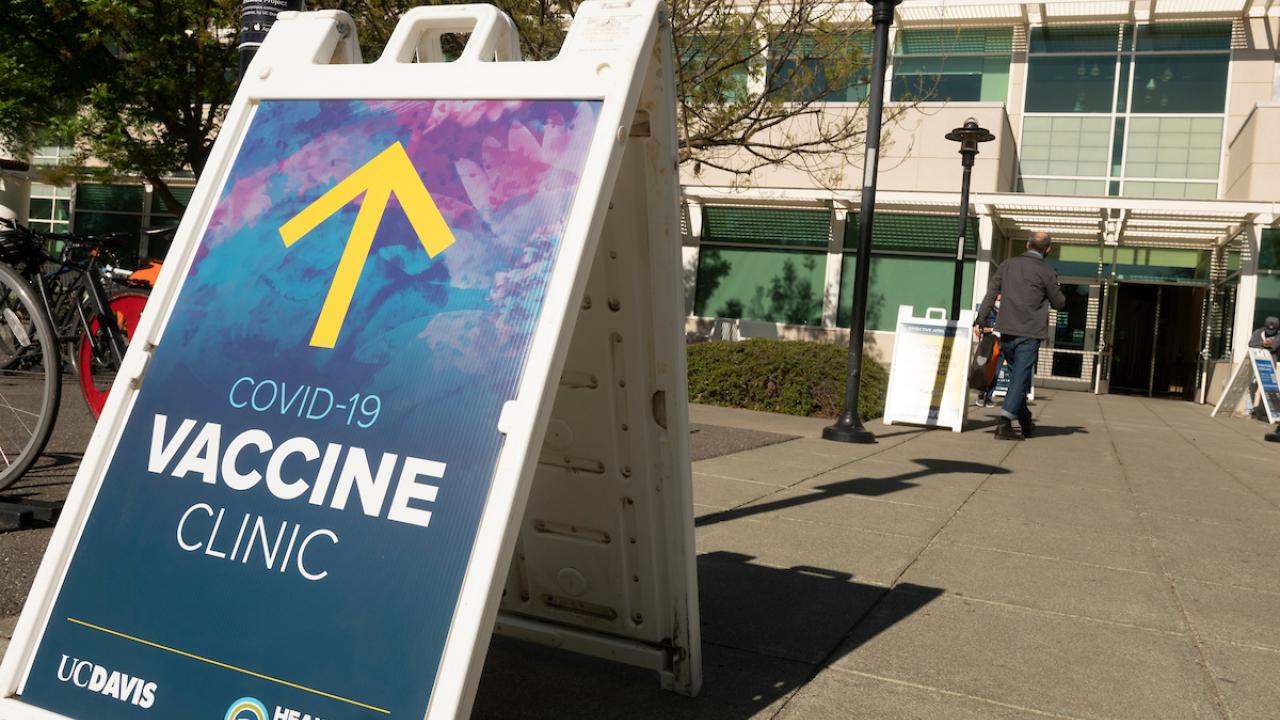 COVID-19 Vaccination Clinic a-frame sign with yellow arrow in front of ARC