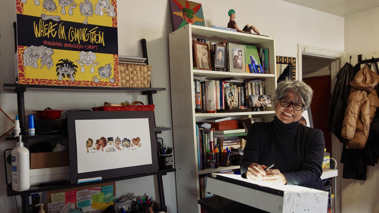 Barbara Brandon-Croft in her office surrounded by her illustrations.