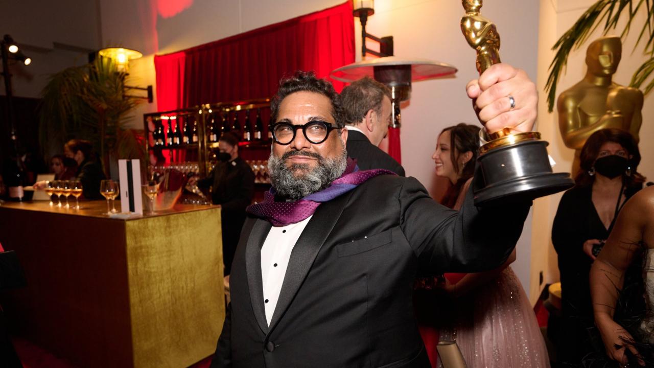 Joseph Patel in tuxedo holding Academy Award