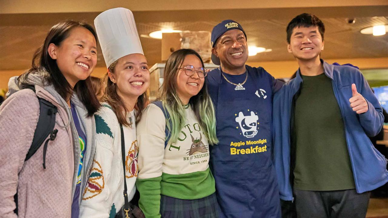 Chancellor Gary S. May poses for photo with students at Moonlight Breakfast event