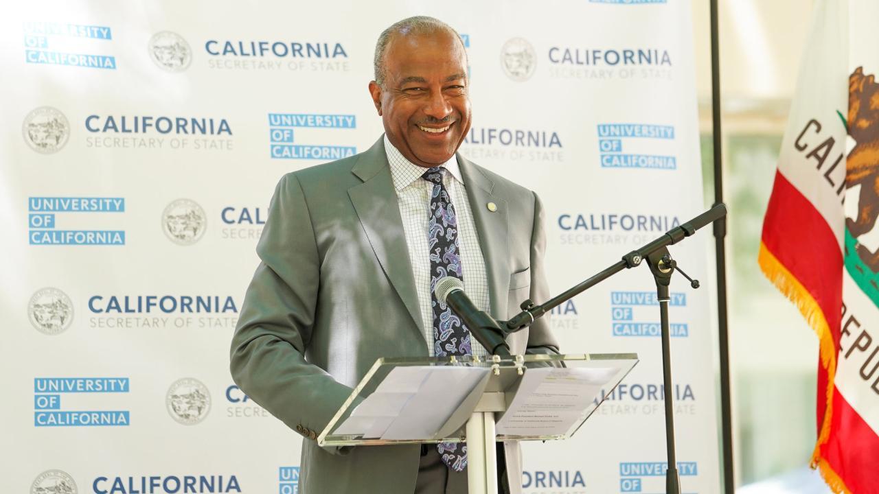 Chancellor May at a podium giving remarks