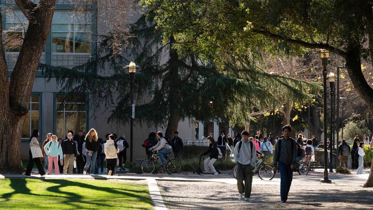 Students walk and ride bicycles outside Shields Library.