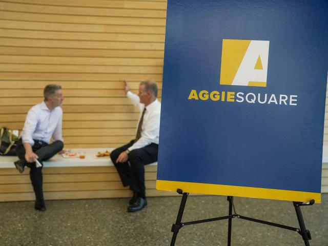 Blue and gold poster board with the words Aggie Square on it
