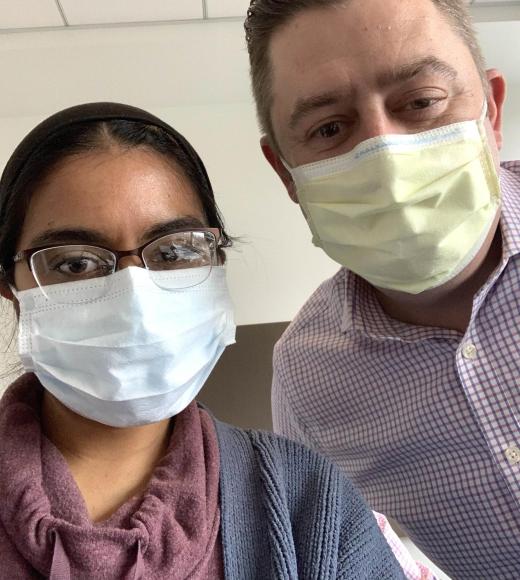 Two people wearing COVID masks look at the camera