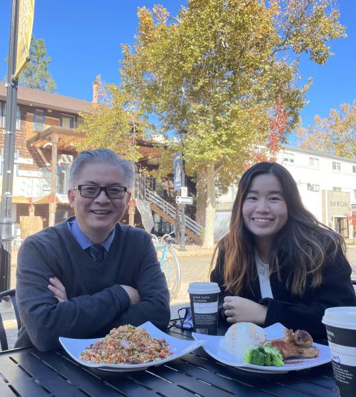 Two people sit at a table with lunch food in front of them