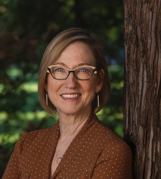 Deborah Agee leaning on tree