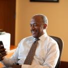 Chancellor May in his office looking at his phone smiling