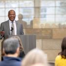 Chancellor Gary May wearing a gray suit and speaking into a microphone