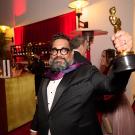 Joseph Patel in tuxedo holding Academy Award