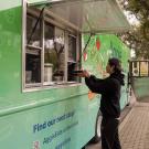 A student receiving an order of food in takeway containers from the Aggie Eats food truck