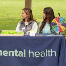 Chancellor May talks with two other individuals at an Aggie Mental Health table.