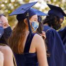 Students wearing grad caps and face coverings.